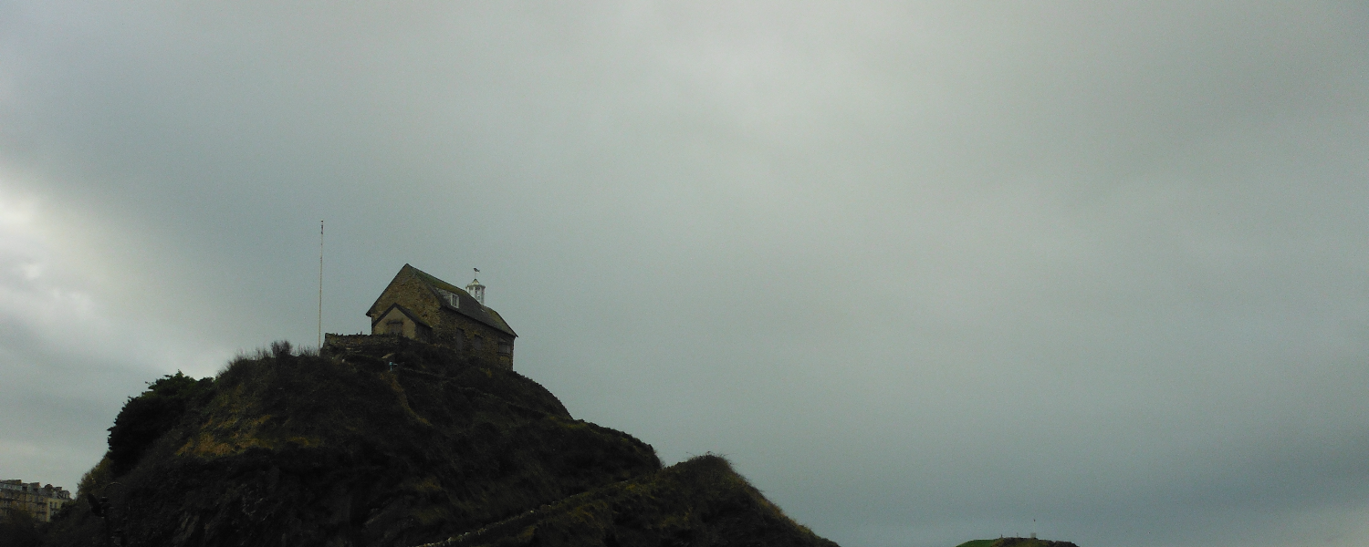 Building on top of a hill, with dark clouds behind, Ilfracombe